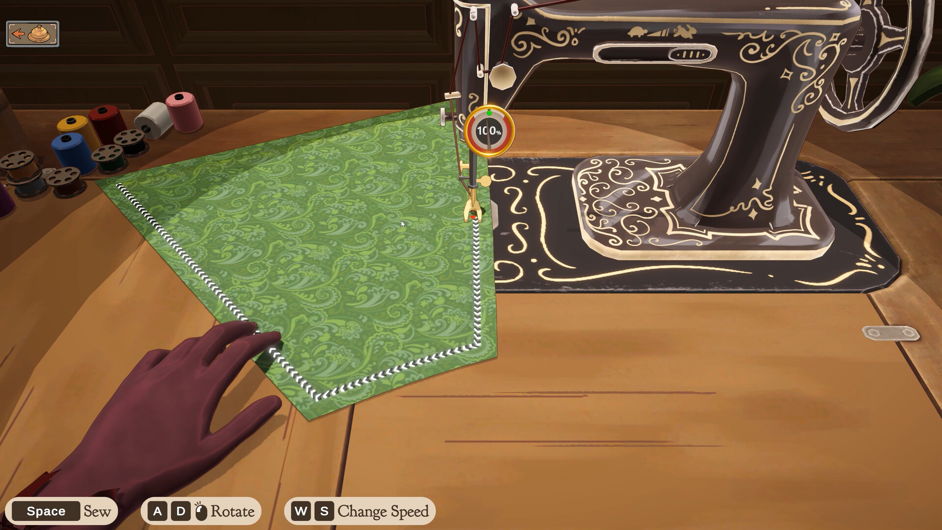 Official Dressmaker screenshot of the sewing scene, with the fabric under the needle and the on-screen control strip reading Space Sew, A D Rotate and W S Change Speed