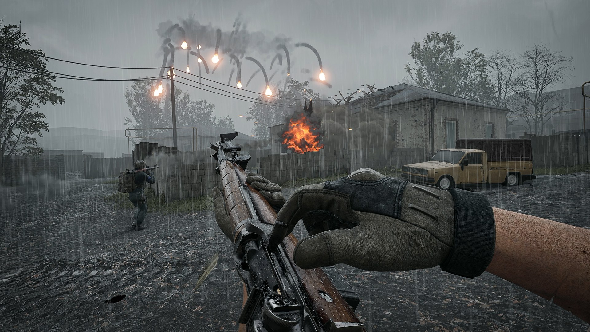 Official WARDOGS Season 2 screenshot of a player holding a bolt-action rifle in heavy rain while tracer rounds arc over a village street