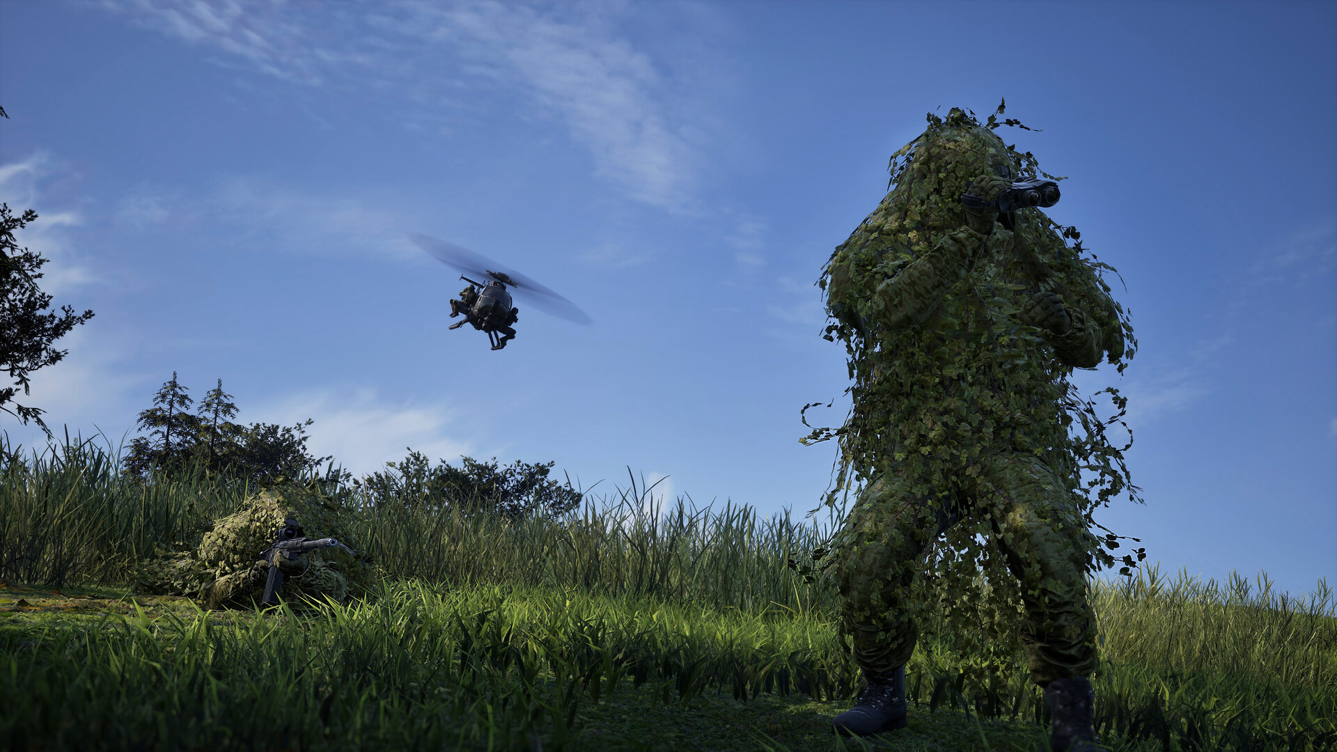 Official WARDOGS screenshot of two ghillie-suited soldiers observing from open grassland while a helicopter flies overhead