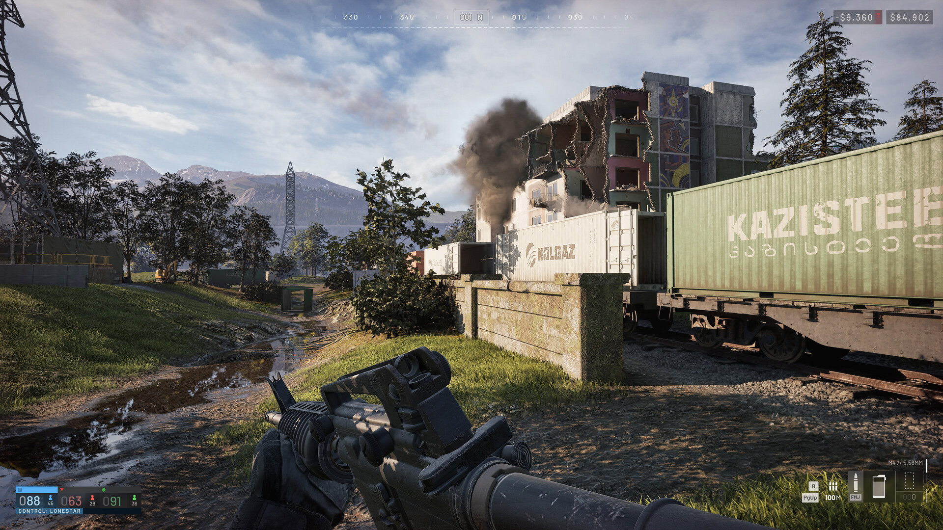 Official WARDOGS screenshot of a freight rail yard with a damaged building burning beyond the tracks, seen from a first-person weapon